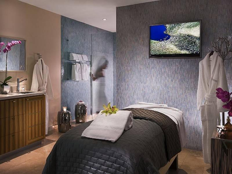 Woman entering the steam room within the massage treatment room at Sunset Marquis.