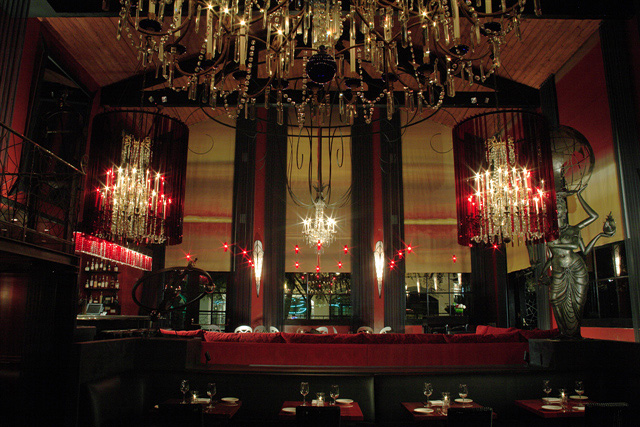 Shot of the dramatic, dimly lit bar at La Boheme, featuring a red color motif and crystal chandeliers. West Hollywood, California.